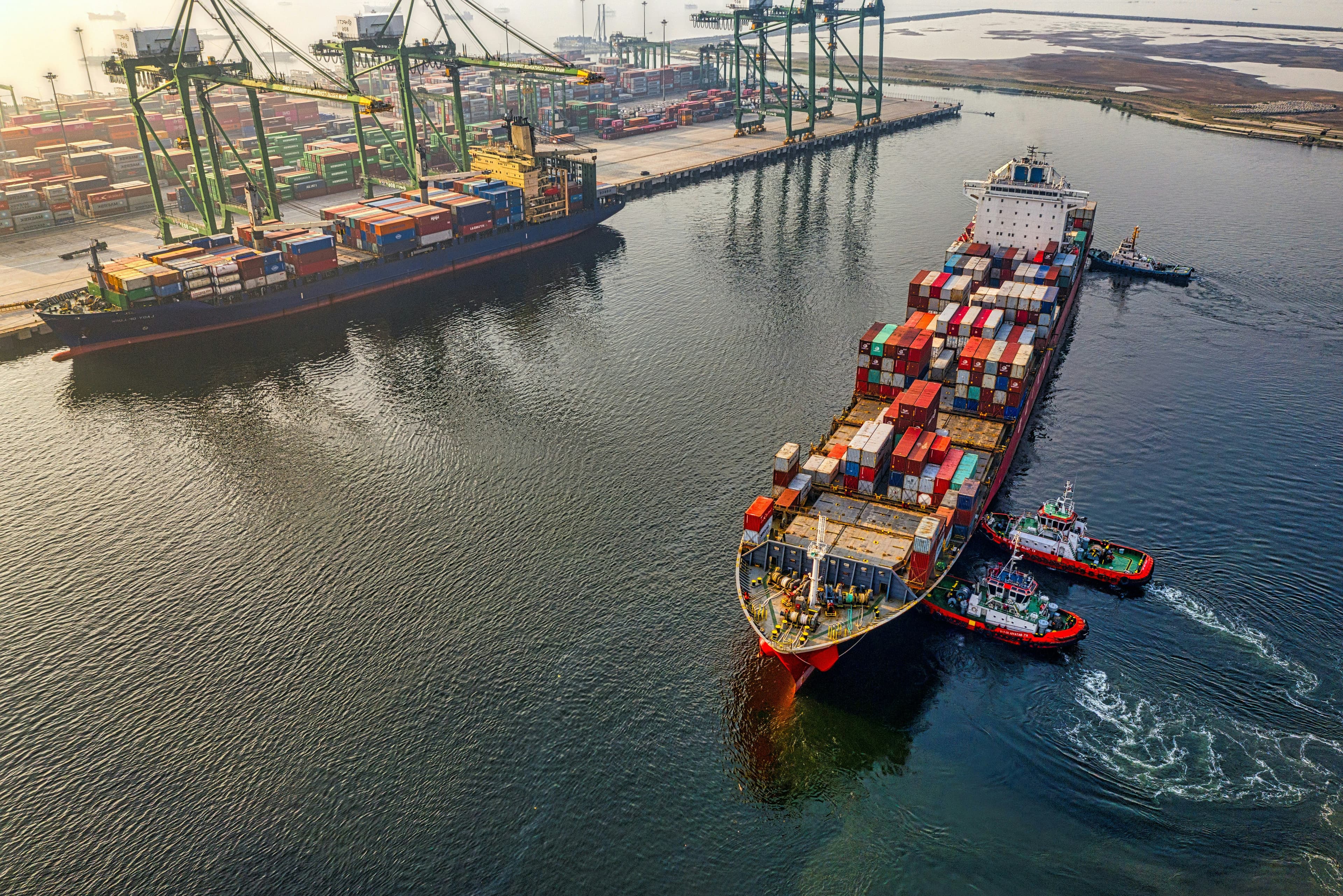 Container stacks and loading cranes at an active shipping port.